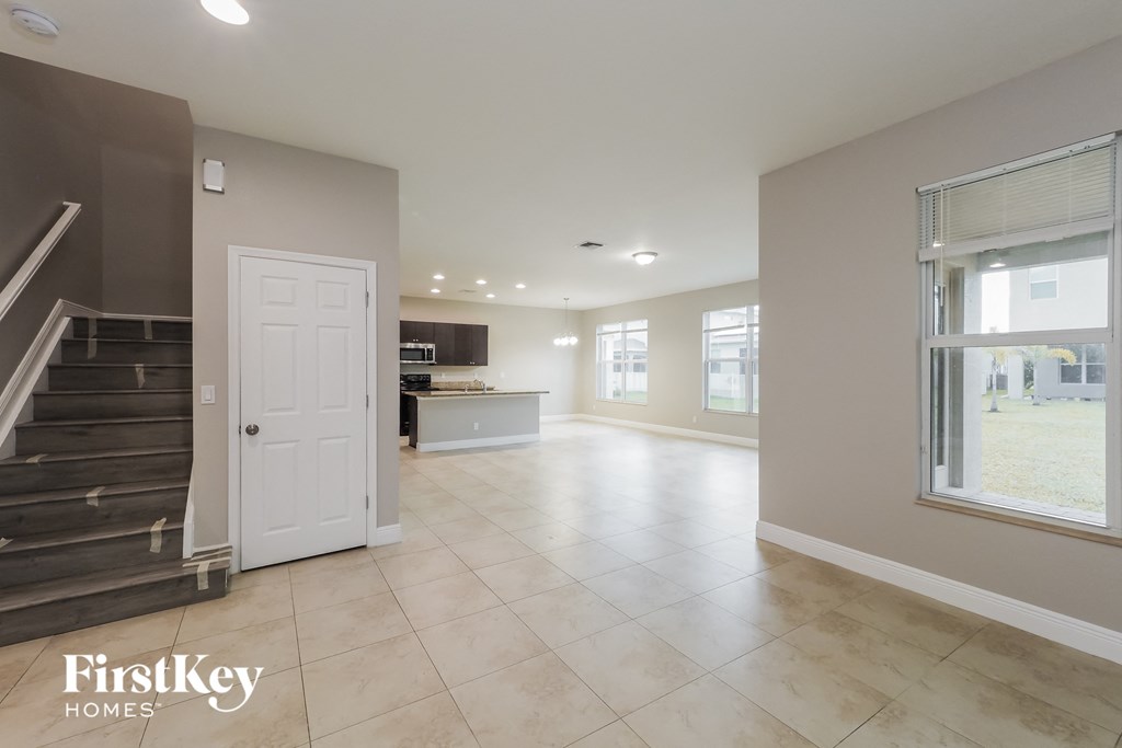 a large living room with a staircase and a white door