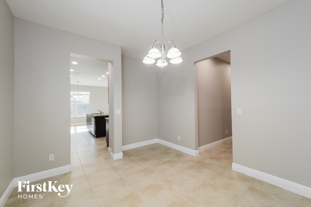 the living room and dining room are spacious and lighted by a chandelier
