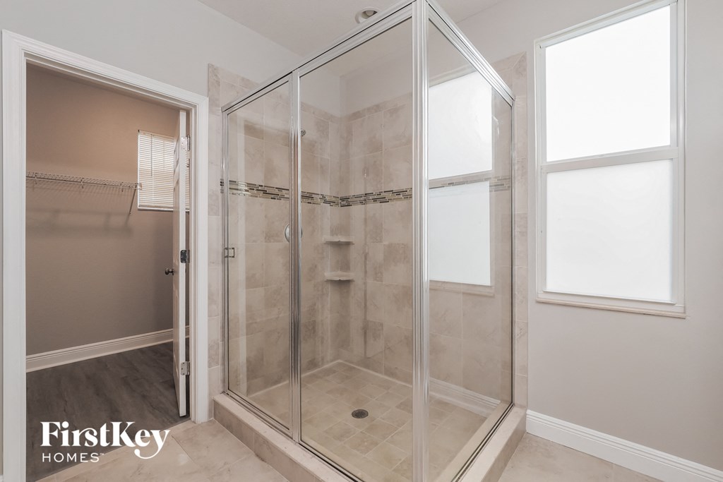 a walk in shower in a bathroom with a glass door