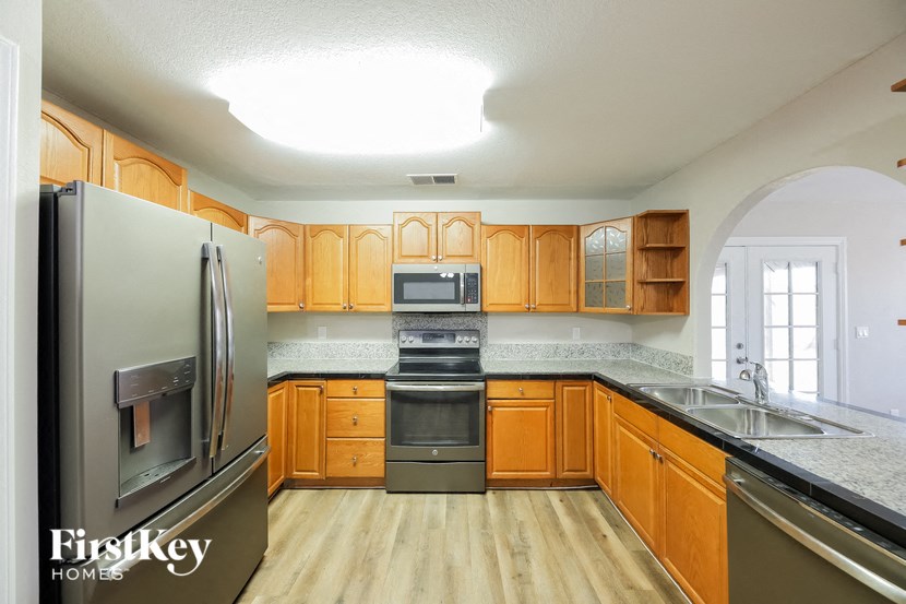 a kitchen with wooden cabinets and stainless steel appliances