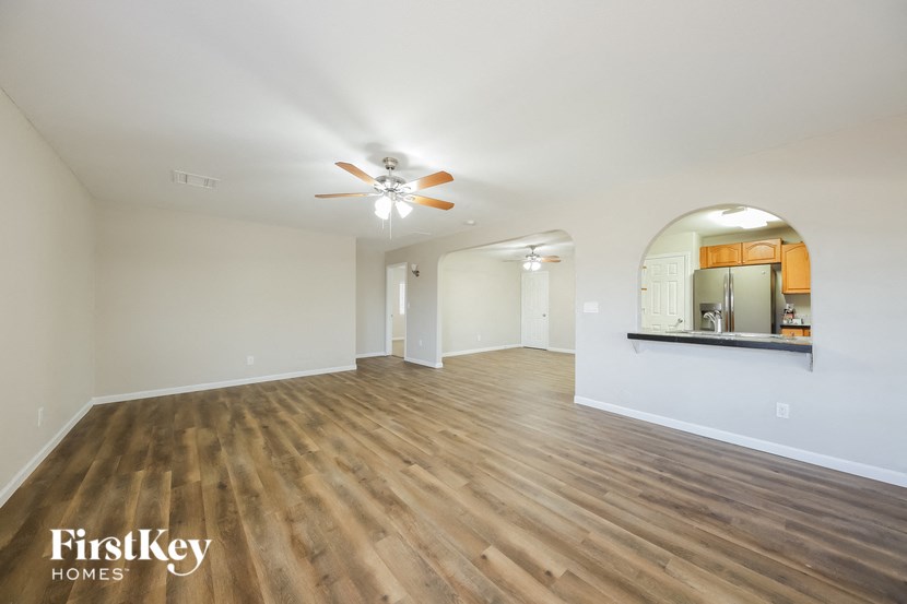 a living room with hardwood floors and a ceiling fan