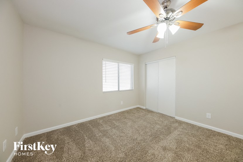 the living room is spacious and clean with a ceiling fan