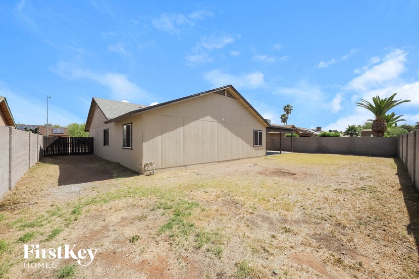 a backyard with a house and a yard and a fence