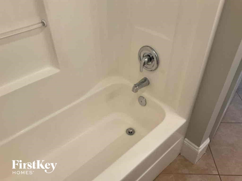 a white bath tub in a bathroom with a sink