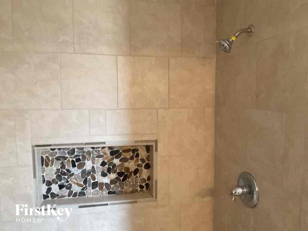 a bathroom with a shower with a tile shower niche and a shower curtain