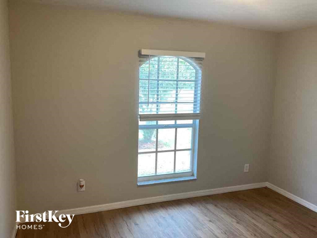 a window in an empty room with wooden floors