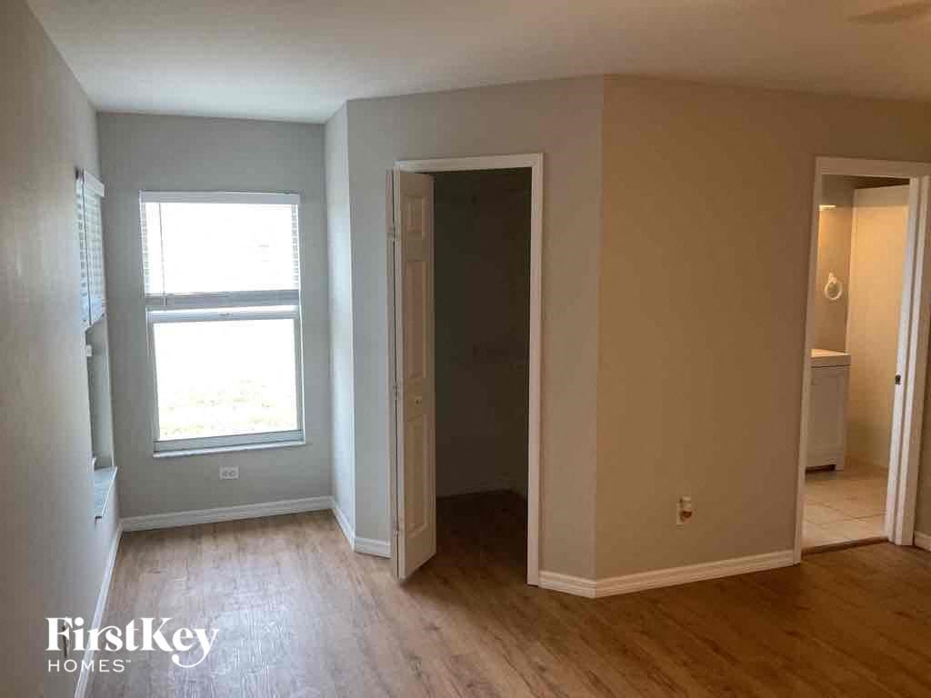 an empty living room with wood floors and a window