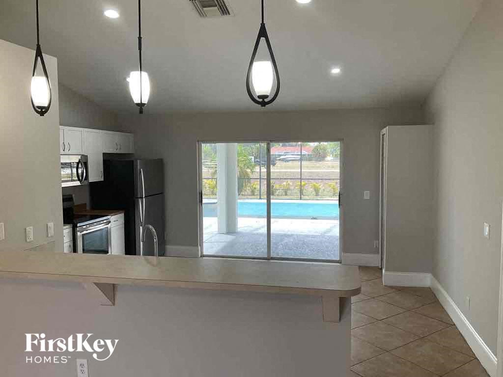 an empty kitchen with a pool in the background