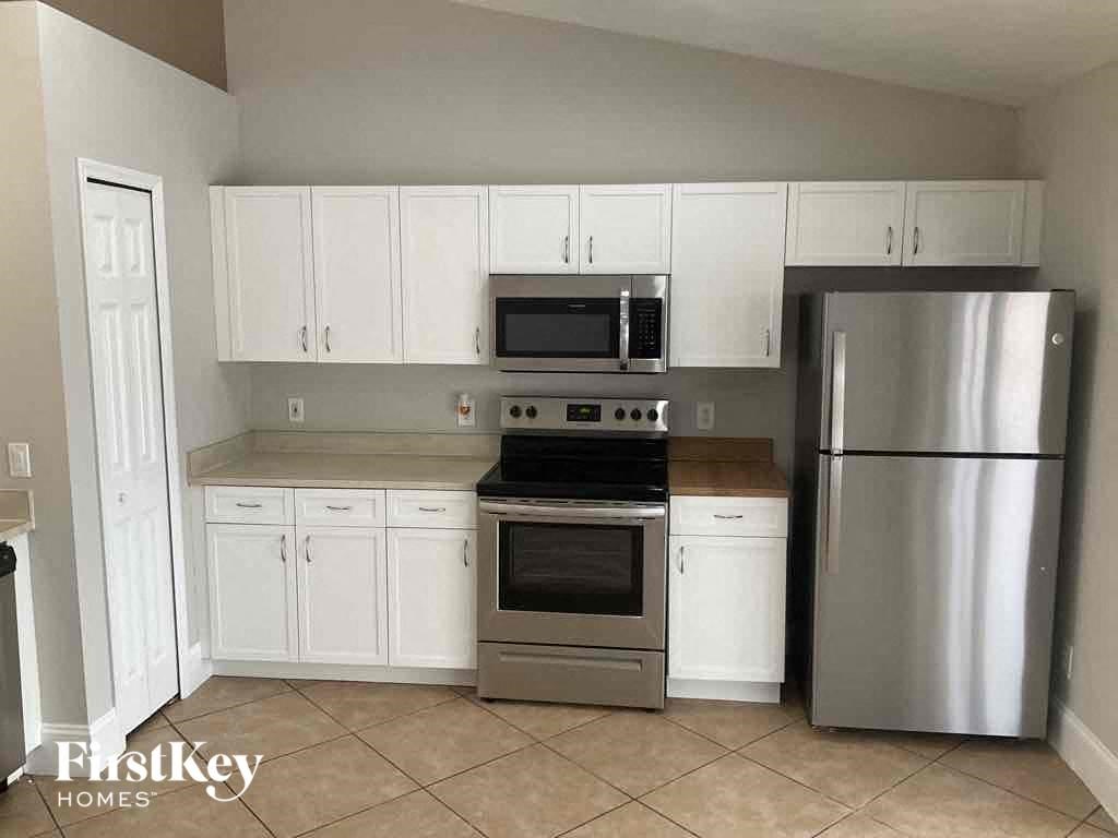 a kitchen with white cabinets and stainless steel appliances