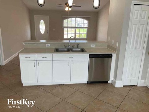 a kitchen with white cabinets and a sink and a dishwasher