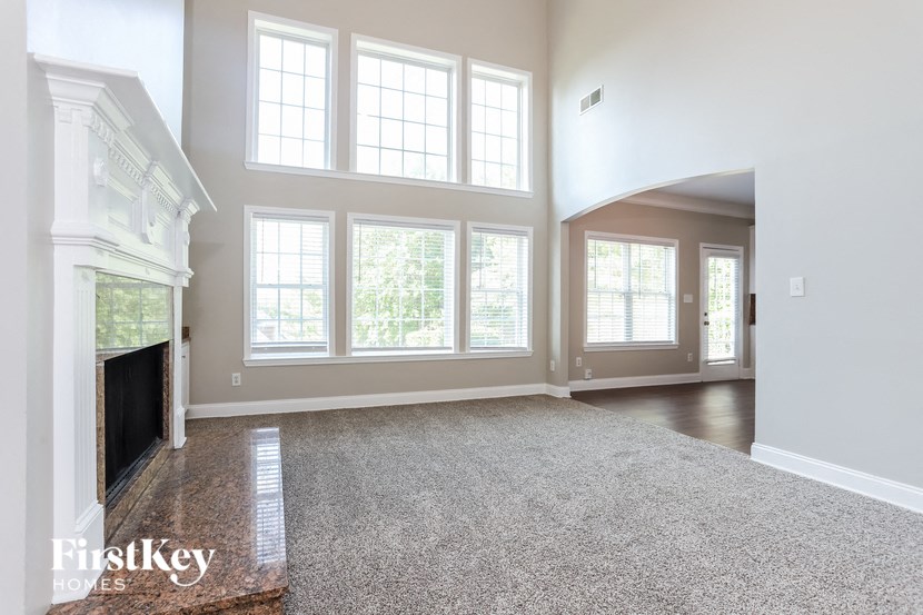 a living room with a fireplace and large windows
