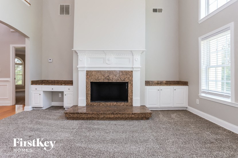 a living room with a fireplace and white cabinets