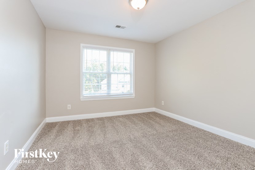 an empty room with carpet and a window
