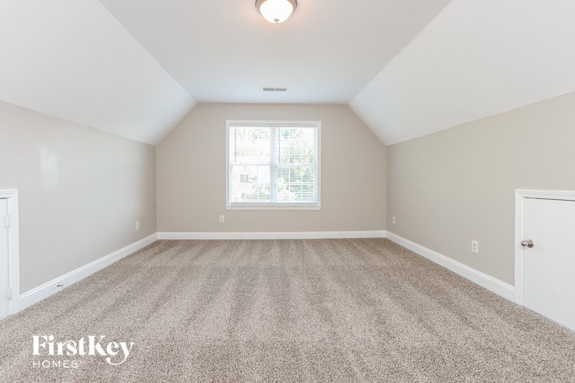 a bedroom with a carpeted floor and a window