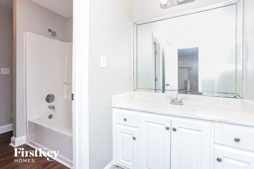 a bathroom with a large mirror and a sink and a shower