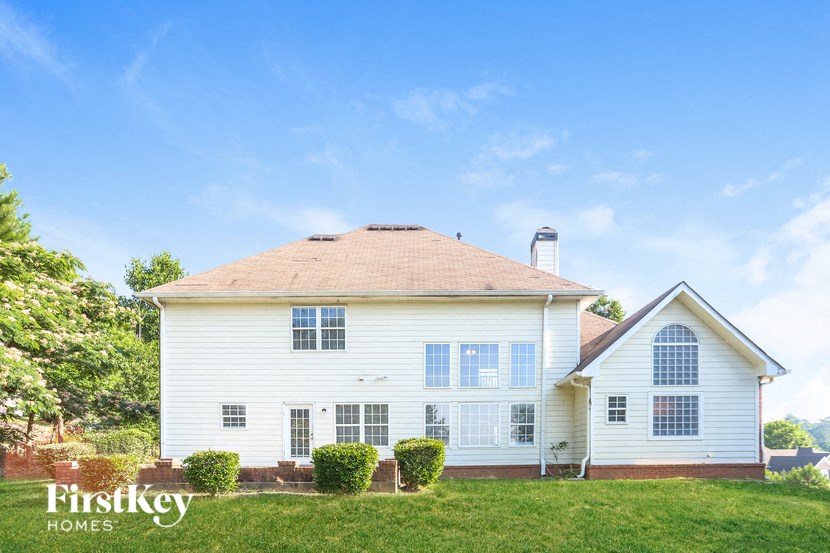 a white house with a brown roof on a green lawn