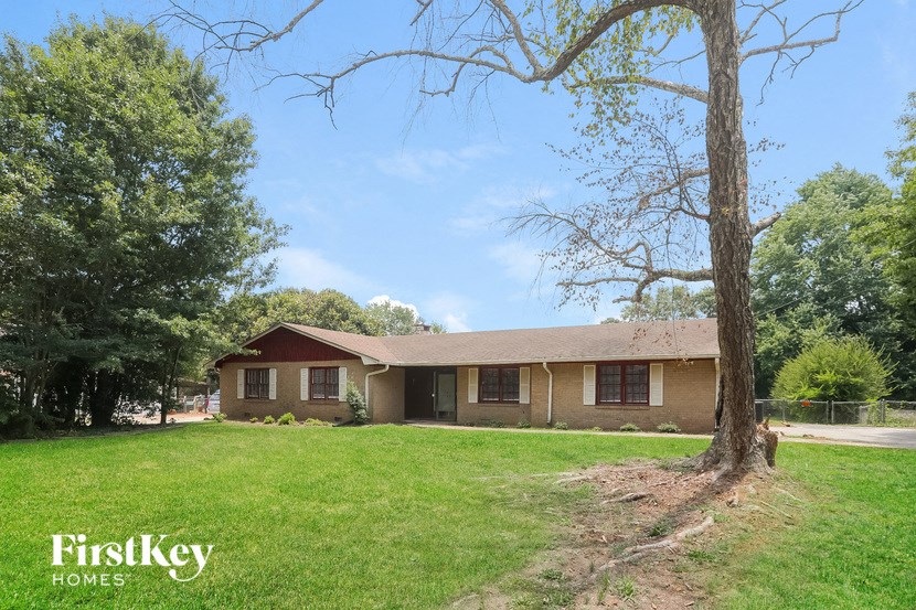 the front of a house with a yard and a tree