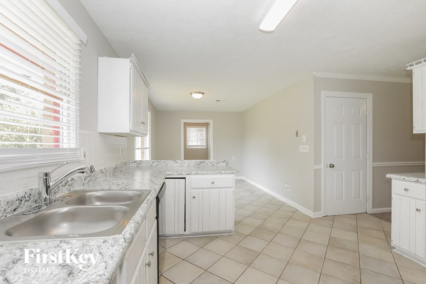 a large kitchen with white cabinets and a sink