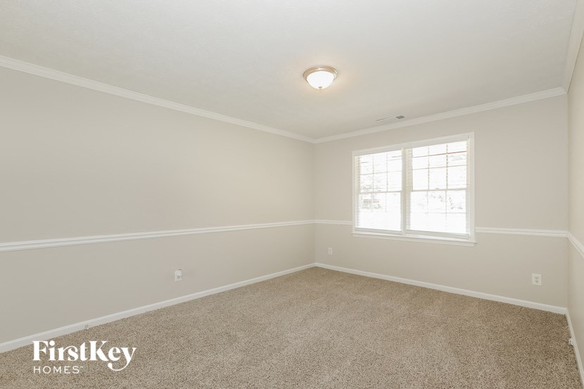 a empty room with carpet and a window