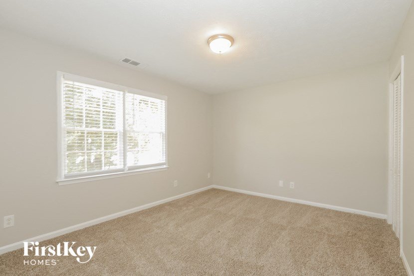a bedroom with a carpeted floor and a window