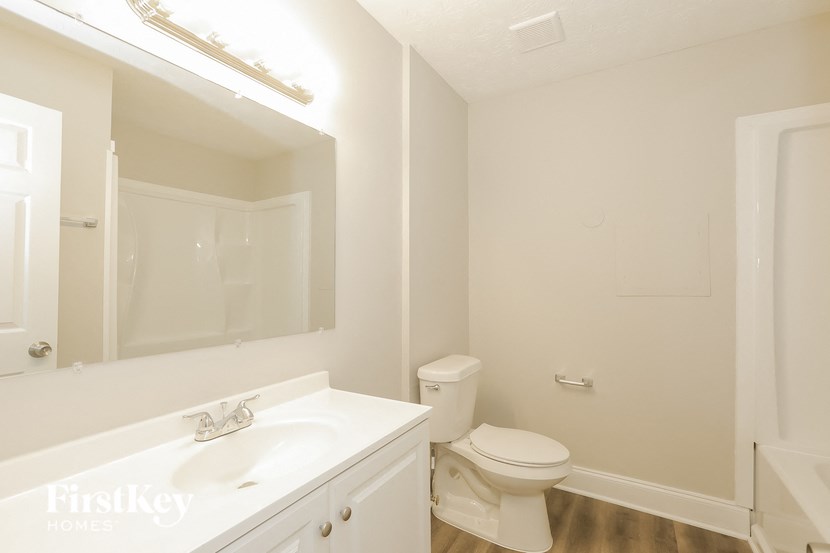 a bathroom with a sink toilet and a mirror