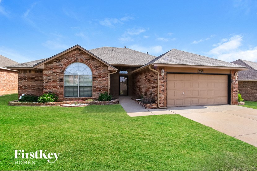 A brick house with a garage door and a driveway.