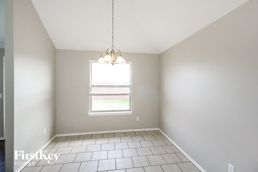 A room with a window and a hanging light fixture.