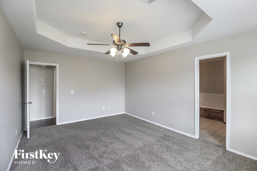 A spacious room with a ceiling fan and carpeted floor.