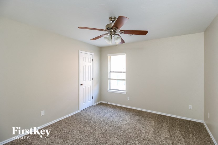 A room with a ceiling fan and a window.