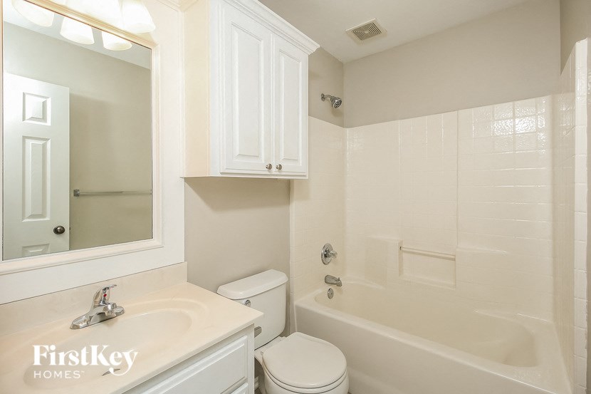 A white bathroom with a sink, toilet and bathtub.