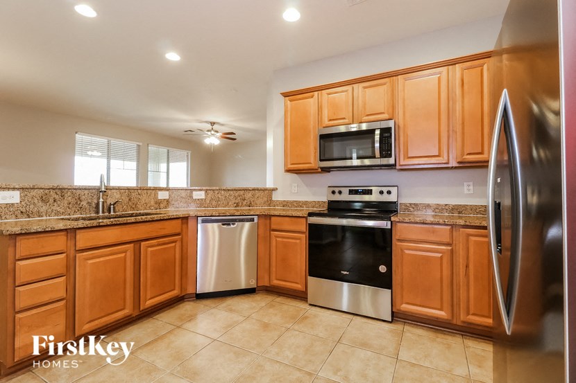 a kitchen with wooden cabinets and stainless steel appliances and a sink