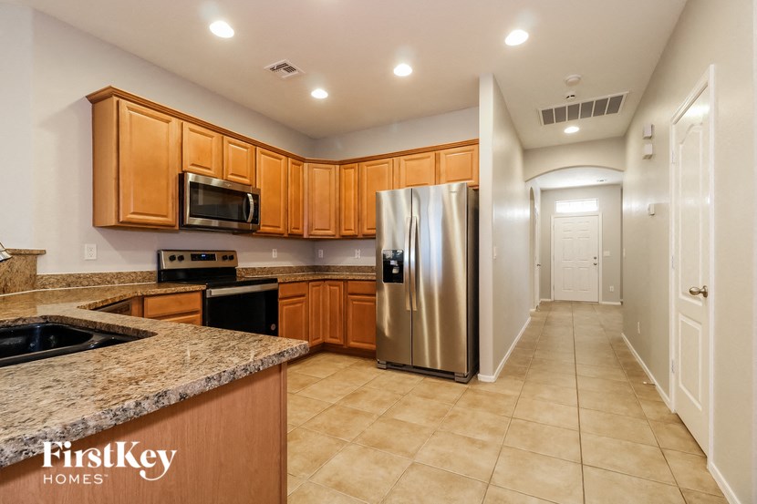a kitchen with granite counter tops and a stainless steel refrigerator