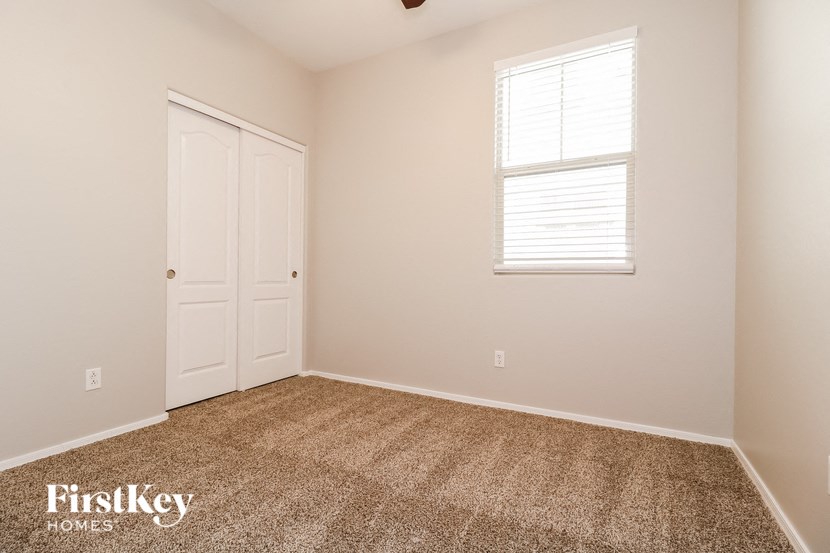 a bedroom with carpet and a window and a door
