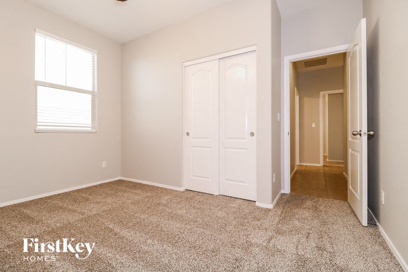 a bedroom with a closet and a door and a window
