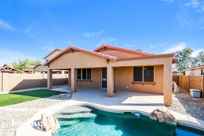 a pool is in front of a house with a pool