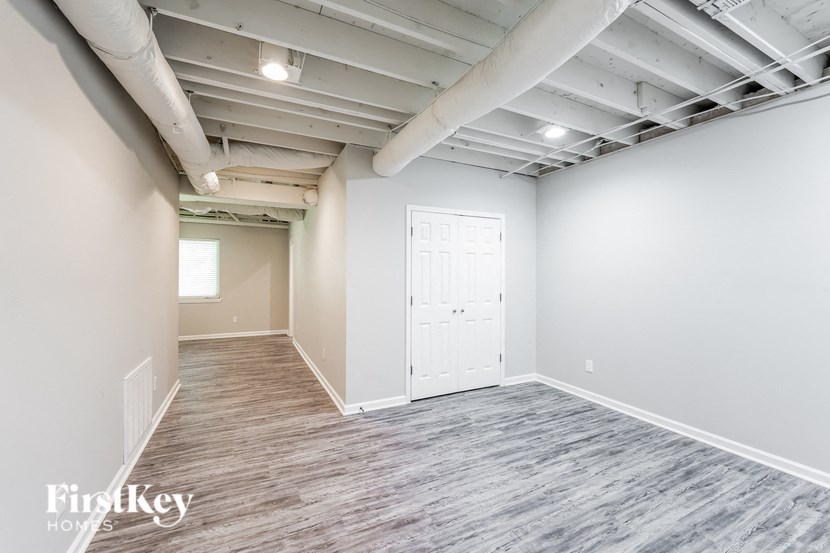 A spacious room with a white door and a window.