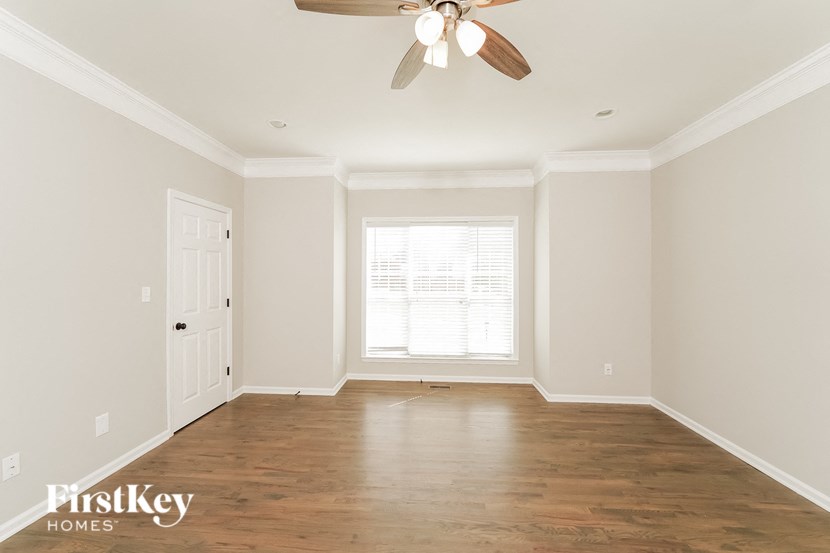 A room with a ceiling fan and wooden floors.