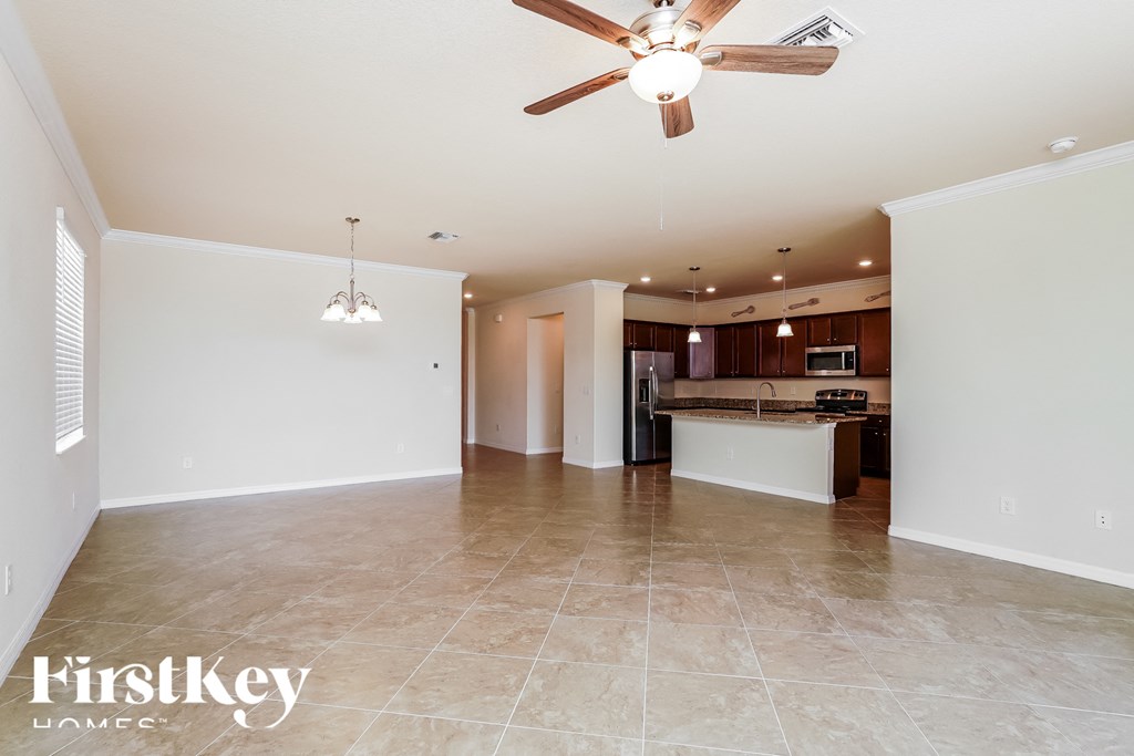 an empty kitchen and living room with a ceiling fan