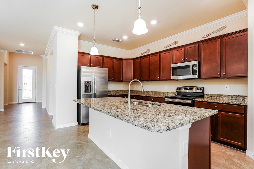 a kitchen with granite counter tops and wooden cabinets
