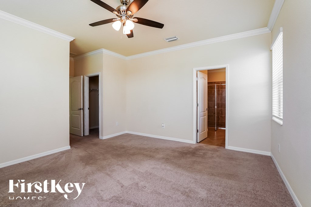 a living room with carpet and a ceiling fan