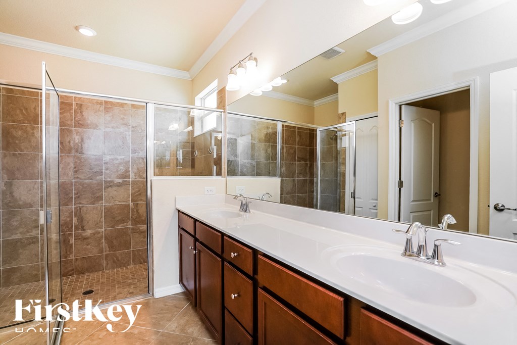 a bathroom with two sinks and a large shower