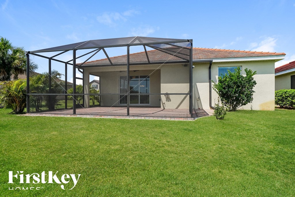 a covered patio with a lawn in front of a house