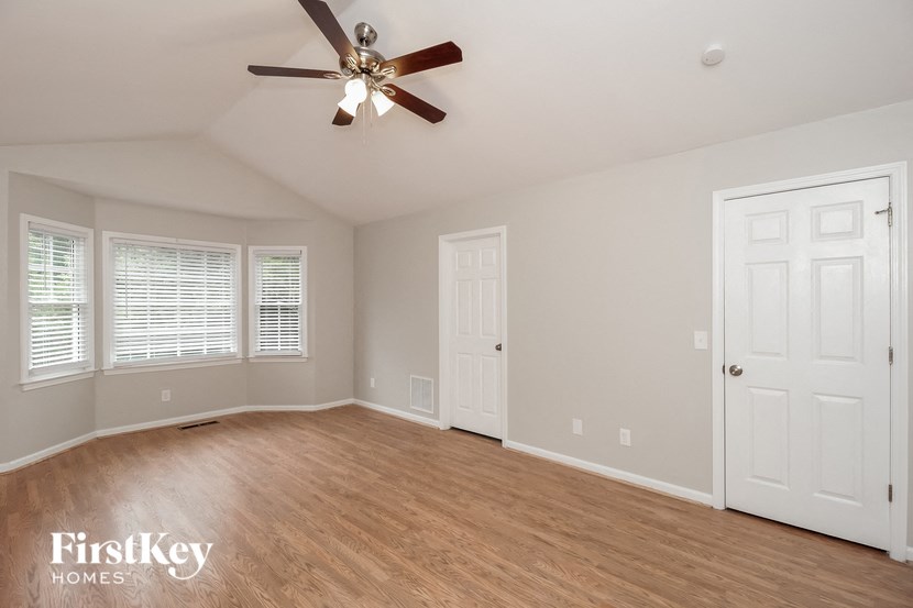 a clean and empty living room with a ceiling fan