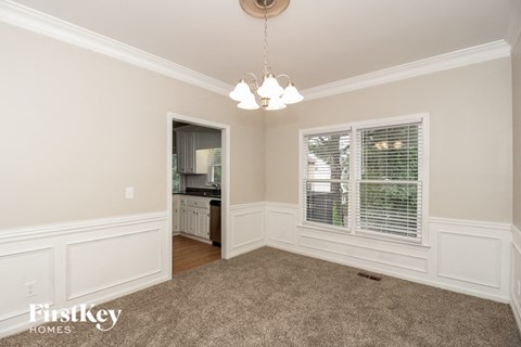 a living room with a large window and a carpet