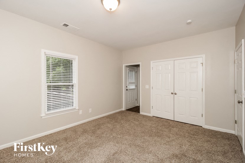 a bedroom with a carpeted floor and white doors