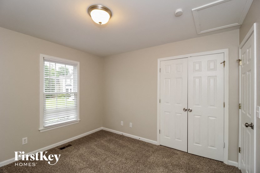 the bedroom of a home with a closet and a white door