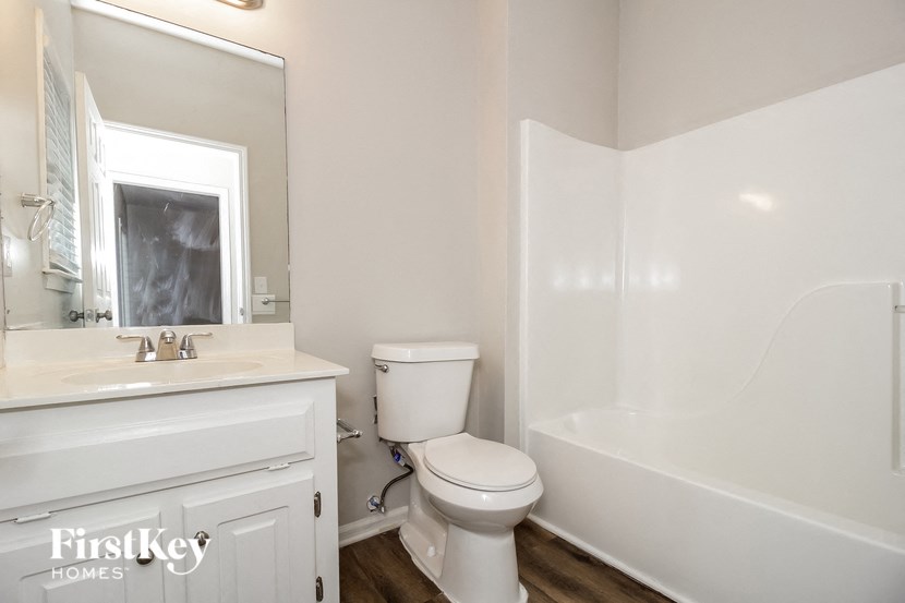 a bathroom with a toilet and a sink and a bath tub