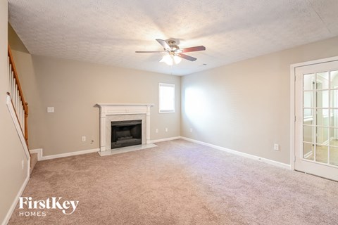 A room with a fireplace and a ceiling fan.