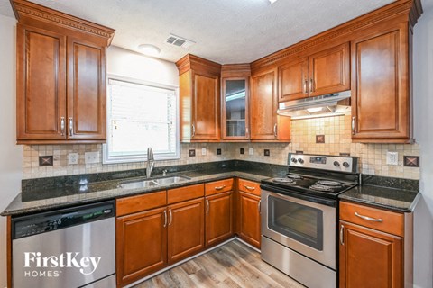 A kitchen with wooden cabinets and a stove top oven.