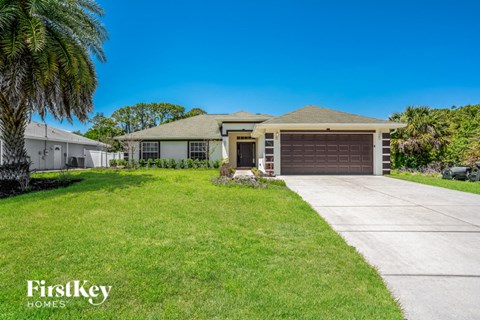 a house with a driveway and a palm tree